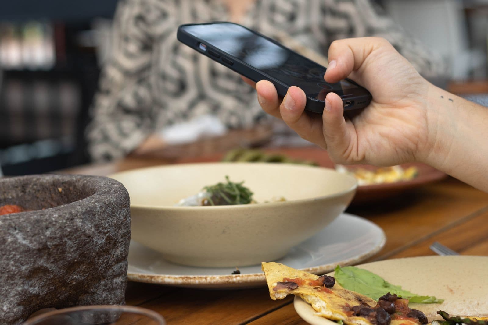 Comensal usando su teléfono durante una comida